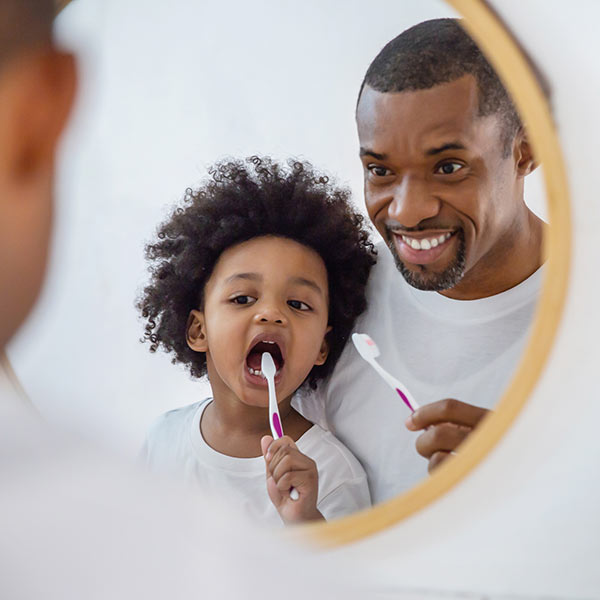 father and daughter brushing teeth together